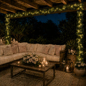Eucalyptus garland with warm white LED string lights frames an outdoor lounge at night - thumbnail number 7