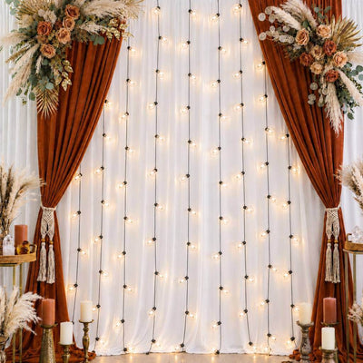 Vertical string lights hanging against a fabric backdrop with floral decor - thumbnail number 5