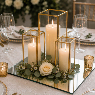 Lit pillar candles in gold-framed glass holders on a square mirror tray with a rose - thumbnail number 3