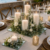 Lit pillar candles in glass cylinders with flowers on mirror glasses for table decor - thumbnail number 5