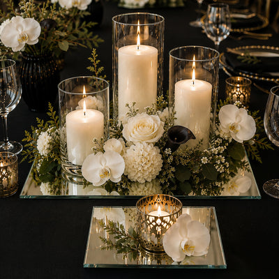 Lit pillar candles, orchids, and white flowers on square mirror table centerpieces - thumbnail number 4