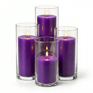 Purple candles in clear glass holders on a white background
