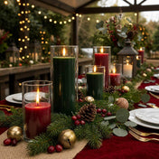 Lit red and green pillar candles in glass vases on a long festive table - thumbnail number 4