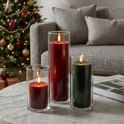 Red and green pillar candles in glass cylinder vases on a table - thumbnail number 6