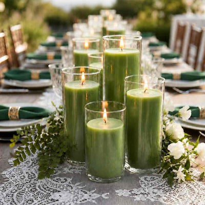 Four green pillar candles in glass cylinders on a lace table runner with white flowers - thumbnail number 4