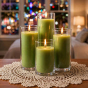 Four green pillar candles in glass vases on a crocheted doily with blurred holiday lights - thumbnail number 6