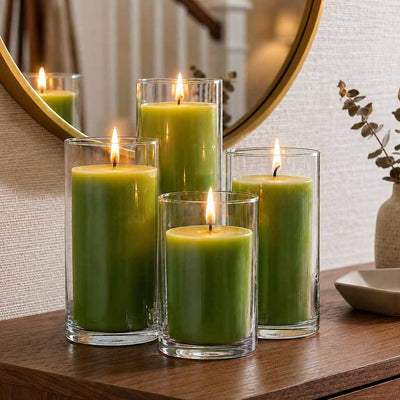 Four green pillar candles in glass cylinder vases on a wooden surface with a mirror reflection - thumbnail number 7
