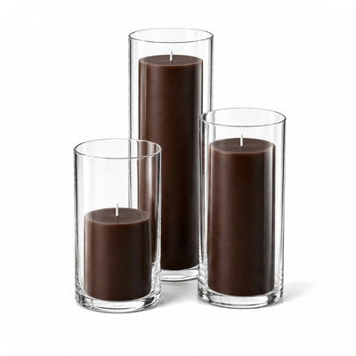 Three brown pillar candles inside clear glass cylinder holders of varying heights - thumbnail number 1