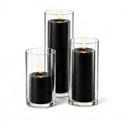 Three lit black pillar candles inside clear glass cylinder holders of varying heights - thumbnail number 2