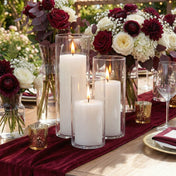 White candles in glass hurricanes surrounded by red and ivory flower arrangements - thumbnail number 5