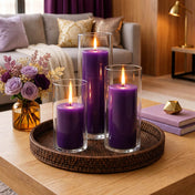 Glowing purple candles in clear glass vases with warm home decor - thumbnail number 7