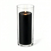 Lit black pillar candle inside a clear glass cylinder vase - thumbnail number 2
