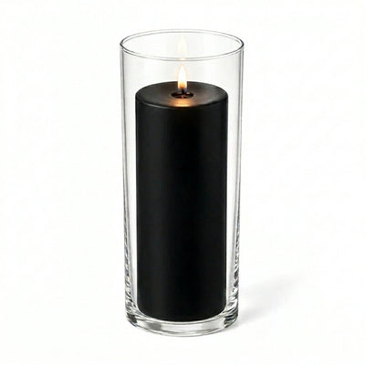 Lit black pillar candle inside a clear glass cylinder vase - thumbnail number 2