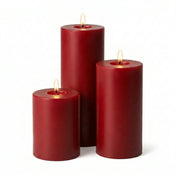 Three lit red pillar candles in staggered heights on a solid white background - thumbnail number 2