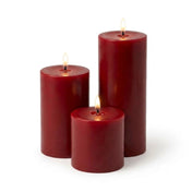 Three lit red pillar candles in assorted sizes on a white backdrop - thumbnail number 2