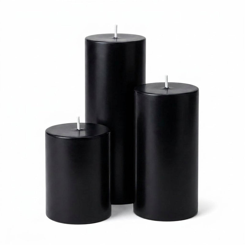 Three unlit black pillar candles in varied heights on a white background - thumbnail number 1