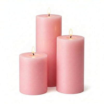 Three lit pink pillar candles in varying heights on a solid white background - thumbnail number 2