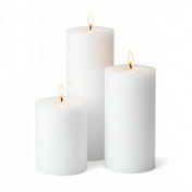 Three lit white pillar candles in assorted sizes on a white background - thumbnail number 2