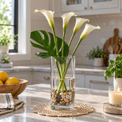 Tall glass vase with stones and white calla lilies on a kitchen counter - thumbnail number 7