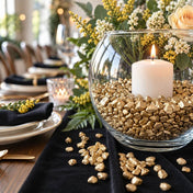 Glass bowl filled with metallic gold stones and a candle on a table - thumbnail number 4