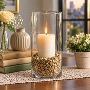 Tall glass cylinder candle holder filled with metallic gold stones and a lit candle - thumbnail number 6