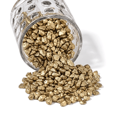 A glass jar spilling out small metallic gold stones for vase filler and decor - thumbnail number 1
