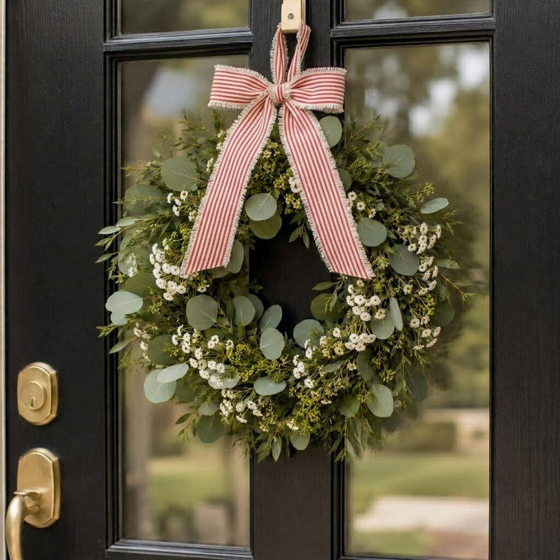 Greenery and white floral wreath hanging on a black door with a red and white striped linen bow - thumbnail number 7