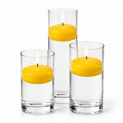 Three yellow floating candles burning inside tall clear glass vases - thumbnail number 1
