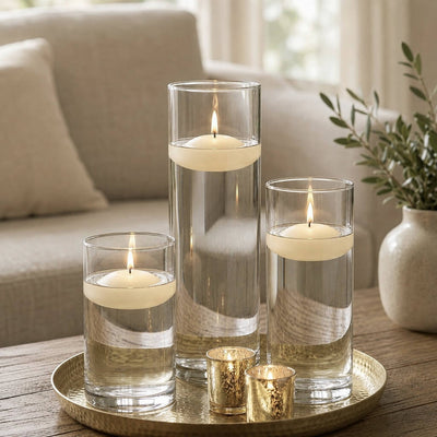 Three lit light ivory floating candles in cylinder vases and two gold votives on a tray - thumbnail number 6
