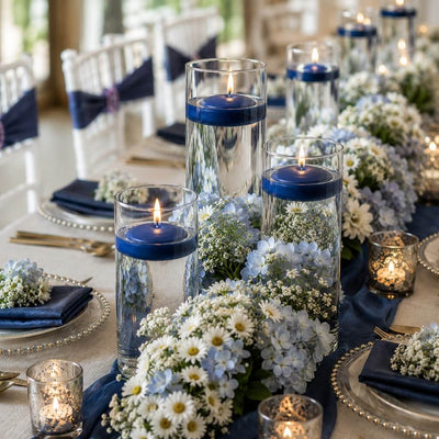 Glass cylinders with floating navy blue candles and blue and white flowers on a banquet table - thumbnail number 3