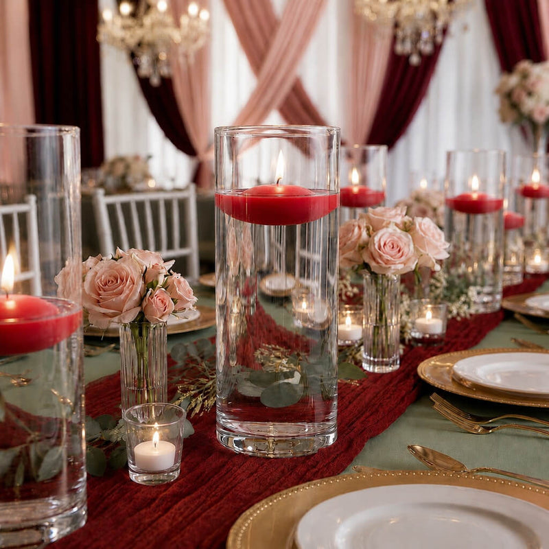 Lit red floating candles in glass cylinders with pink roses on a table - thumbnail number 3