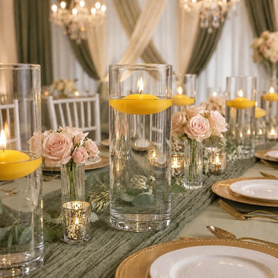 Lit yellow floating candles in glass cylinders with pink roses on a table - thumbnail number 4