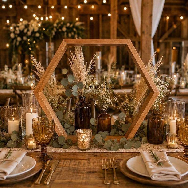 Rustic wood hexagon frame centerpiece with pampas grass, amber bottles, and candles on a table - thumbnail number 3