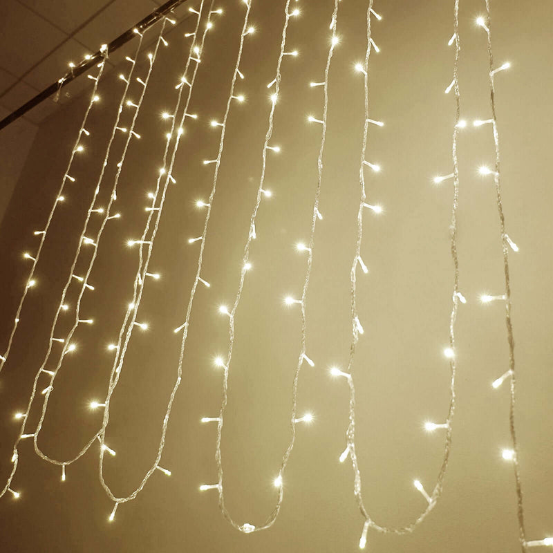 Warm white LED curtain lights hanging in vertical strands against a plain wall - thumbnail number 1