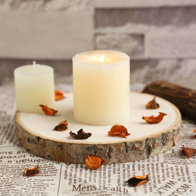 Candle on a wooden slice with dried petals on newspaper background. - thumbnail number 1