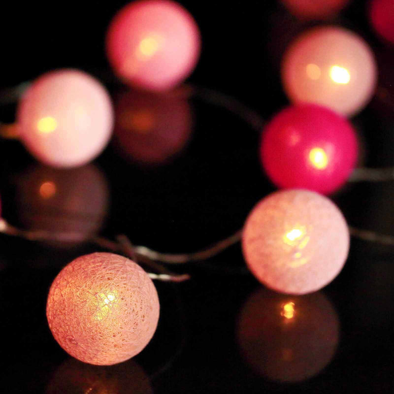 Pink cotton ball string light garland glowing on dark background - thumbnail number 1